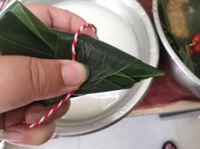 捏住收口的位置，轻轻的缠上绳子。