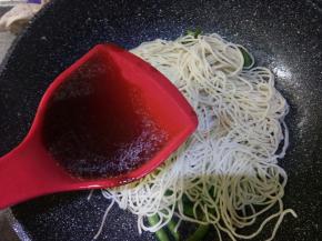 拿一半面条抖散铺在豆角上，均匀淋一半汤汁进去