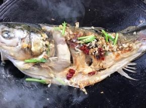 加入姜末、蒜末、干辣椒和葱段爆香，再放在鱼身上