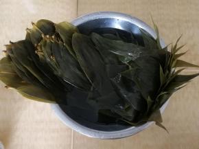 等温度降下来，把粽叶两面用刷子刷洗干净，再冲洗一遍。然后取一盆，放入半盆清水，把刷干净冲干净的粽叶泡入。
