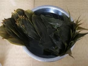 等温度降下来，把粽叶两面用刷子刷洗干净，再冲洗一遍。然后取一盆，放入半盆清水，把刷干净冲干净的粽叶泡入。