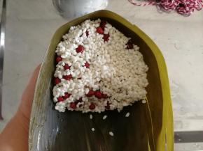 再盖上适量糯米。怕包不好。就少放一些。压一下略微压实。