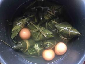将绑好的粽子放入电饭煲中，倒入没过粽子的水量，2个煮饭程序至自然放气即可；