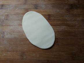 除黑豆外，将所有食材放入面包机搅拌成面团，醒发五分钟，分切小份，取一份幹成椭圆形厚面片