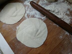 面团搓成长条分切小块，每一小块幹成中间厚，边缘薄的面皮