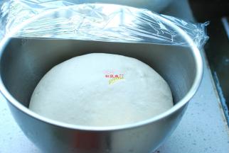 准备好所需要的食材，面粉内加入酵母、白糖、清水，先用筷子搅拌成絮状，然后下手揉成光滑的面团，盖上保鲜膜，放在温暖的地方发酵。