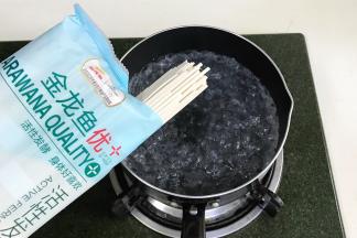 锅中倒入适量的清水烧开，放入金龙鱼优+活性发酵空心挂面。