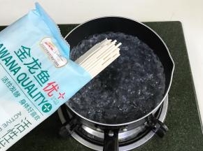 锅中倒入适量的清水烧开，放入金龙鱼优+活性发酵空心挂面。