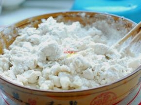 面粉放在盆子里，加入开水，先用筷子搅拌成大疙瘩，再放入适量的冷水，下手揉成一个柔软又光滑的面团。