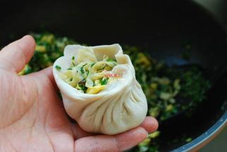 取一个馅饼皮放入适量韭菜鸡蛋馅，包成小包子的形状。如果你是新手，馅要少放一点，不然很难包住。