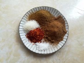 准备一个盘子，五香粉、孜然粉、白砂糖、盐和辣椒粉放一起，避免漏掉了。辣椒粉的份量根据口味来放，喜欢吃麻辣口味的可以加点花椒面