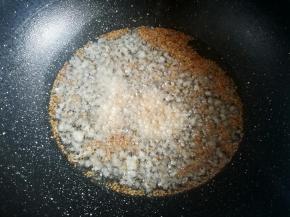 热锅后放入食用油，把蒜蓉和白芝麻一起下锅，小火炸出香味