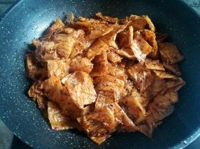 用锅铲快速的翻拌均匀，让每一块豆皮都均匀的裹上香料