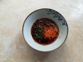 把生姜碎，蒜米，葱花和小米椒放入碗里，加上2勺酱油，1勺香醋，一勺辣椒油，半勺白糖和半勺白芝麻，混合均匀