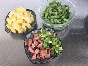 将土豆切成小块、豆角切段、火腿切丁、葱切小段。