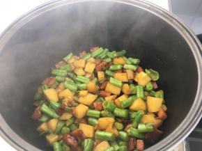 将炒好的菜倒入电饭煲中。