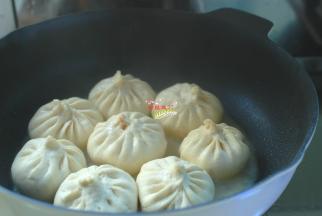 时间到了，包子变得胖胖的就好了，开火，先小火慢慢煎出底部一层焦黄的硬皮儿，加入1勺食用油，盖上盖子再煎3分钟，加入半碗面粉水，盖上盖子，焖煎8分钟至包子熟透就好了，出锅后带着透明的冰花儿。我家孩子就馋这份带着冰花的水煎包，又脆又香，吃一锅都不够。