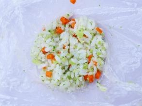 取一块保鲜膜，将饭团放入保鲜膜中压扁。