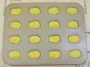 取出冷藏好的蛋糕糊，挤入12连的小玛德琳模内，每个玛德琳模大概8分满即可。