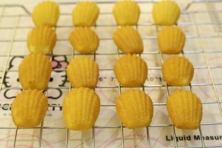 出炉的玛德琳轻轻一推就可以脱模，放在晾架上放凉备用。