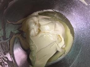 把蛋清分两次加入到黄油中，用电动打蛋器搅拌均匀，然后再把剩下的蛋清加入，继续搅拌均匀。