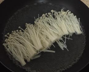 锅里烧热水，把洗干净的金针菇放入锅中焯水。