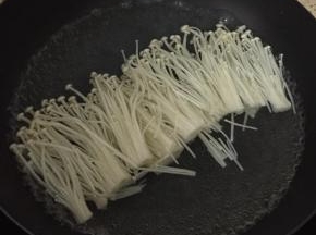 锅里烧热水，把洗干净的金针菇放入锅中焯水。