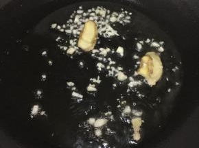 锅烧热倒油，把大蒜、姜片放入炒出香味。