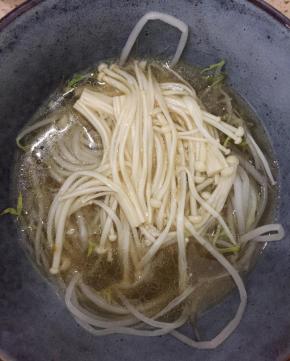 把豆芽和金针菇放在一大碗中，把煮好的酸汤倒入。