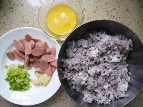 准备好所需要的食材，把鸡蛋打散、鸡肉肠切片、香葱切小段、大蒜切碎备用。