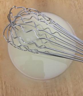 制作蛋糕糊。将玉米油和水倒入打蛋盆中，用打蛋器搅拌均匀，充分乳化。