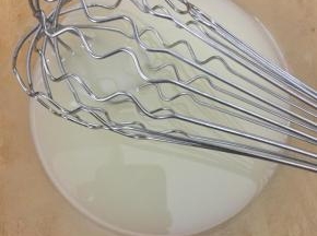 制作蛋糕糊。将玉米油和水倒入打蛋盆中，用打蛋器搅拌均匀，充分乳化。