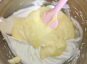 把拌匀的面糊倒入到剩余的蛋白霜中，继续翻拌均匀。