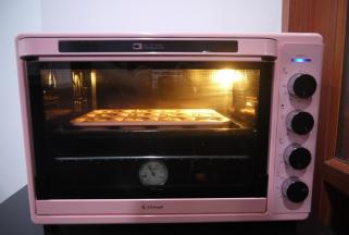 把模具放在一个稍大的烤盘中，烤盘中加入热水，然后把烤盘和蛋糕一起放入预热好的烤箱中，上下火150度，水浴法烘烤35分钟。