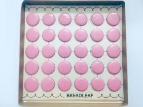 在马卡龙垫上垂直挤出大小均匀的圆形，挤好后震几下，震出气泡