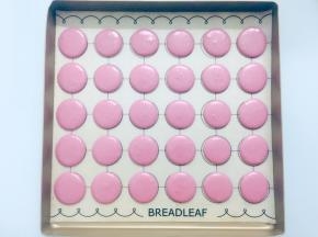 在马卡龙垫上垂直挤出大小均匀的圆形，挤好后震几下，震出气泡