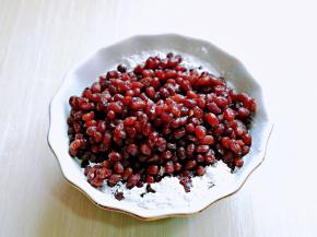 将蜜豆放入糯米粉器具中，翻拌均匀。