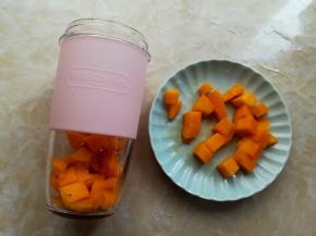 把牛奶倒入无线果汁杯里，加入适量的芒果肉，芒果肉不要全部放完，留一些后面放甜品碗里