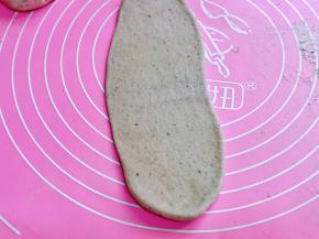 取一块醒发好的面团，用擀面杖擀成椭圆形。