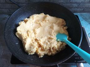 把绿豆泥放入不粘锅里中小火加热，分2-3次加入葵花籽油，每次让绿豆泥把油吸收好了再加