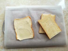 蒸脆皮肠的时候，把吐司切成3片，用擀面杖把吐司片擀长擀薄一些，宽度要比脆皮肠的长度稍微宽一些才能包住脆皮肠，擀土司片的时候可以开始预热烤箱，上下火200度5分钟