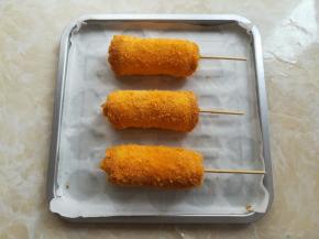 卷好的香肠芝士卷放到铺有油纸的盘子里，这样比较方便清洁烤盘