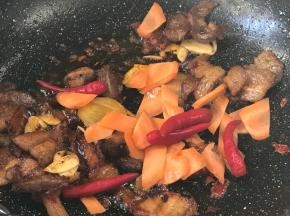 加入胡萝卜和小米辣翻炒至断生