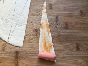 手抓饼抹上番茄酱，放上火腿肠，从下向上卷起