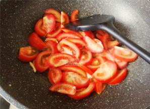 锅中倒入少许食用，把切块的番茄倒入翻炒，炒出汁水。