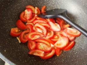 锅中倒入少许食用，把切块的番茄倒入翻炒，炒出汁水。