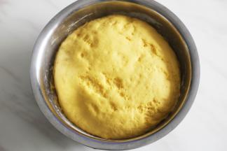 面团发好以后，面板撒上干面粉，取出面团揉一下排出气体再进行二次发酵。