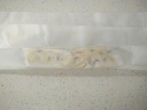 包上油纸，用双手捏住面团中间位置，向相反方向捏塑型成长方形，再把其它三个面都用同样方法，打开油纸用手整理面团两端。