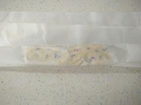 包上油纸，用双手捏住面团中间位置，向相反方向捏塑型成长方形，再把其它三个面都用同样方法，打开油纸用手整理面团两端。