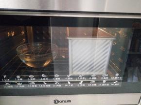 放进烤箱进行第二次发酵，底部放一盆热水，大约发至模具的九分满，就可以进行烘烤了。